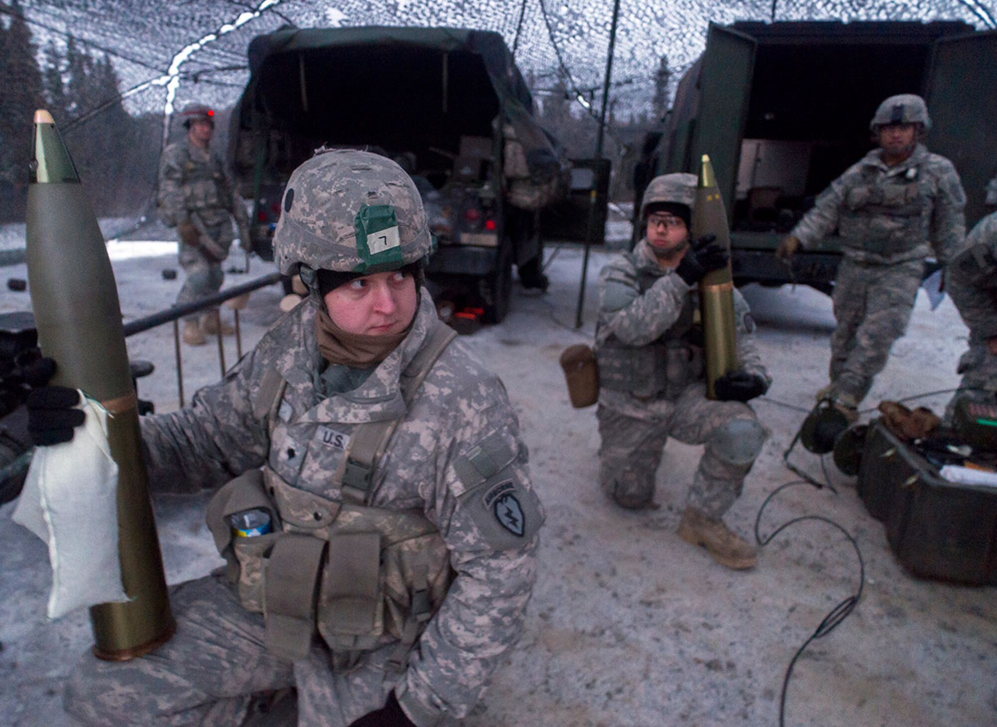 Spc. James Rolf, a native of Oakland, Md., and Army Pfc. Emilio Ojeda, left, a native of Madera, Calif., both assigned to B Battery, 2nd Battalion, 377th Parachute Field Artillery Regiment, 4th Infantry Brigade Combat Team (Airborne), 25th Infantry Division, U.S. Army Alaska, wait to hand off ammunition during a live fire with M119A2 105mm howitzers, Monday, Jan. 11, 2016. USARAK is home to the Army’s only Pacific airborne brigade combat team, and maintains the only airborne rapid-response capacity within the Pacific Command Area of Responsibility.  (U.S. Air Force photo/Justin Connaher)