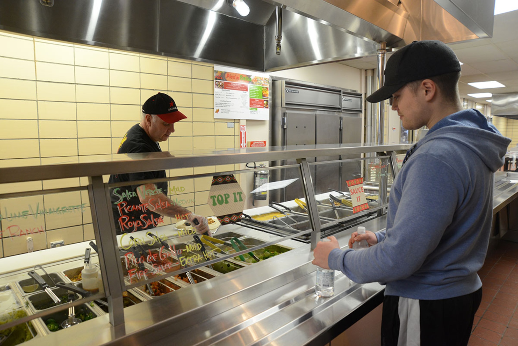 Airman 1st Class Bret Chamblee, 90th Aircraft Maintenance Unit F-22 Raptor crew chief, chooses the ingredients for his order at Pico ‘n Salsa at Joint Base Elmendorf-Richardson, Alaska, Jan. 11, 2016. All entrées have the choice of meat, rice, various vegetables and sauces for the customers to customize their meal. (U.S. Air Force photo by Airman 1st Class Christopher R. Morales)