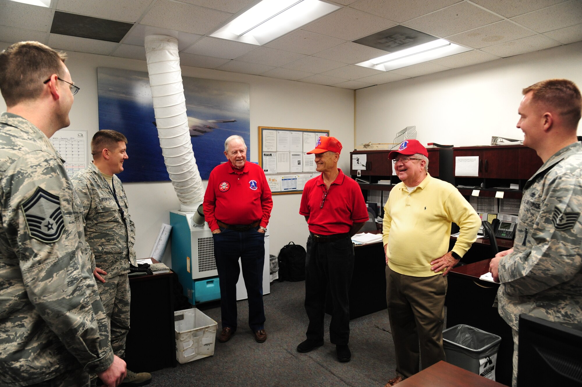 Charlie Brown, the 13th Bomb Squadron Association (BS) president, center left, Charlie Breitzke, a 13th BS Association volunteer, center, and Bob Parks, the 13th Bomb Squadron Association vice president, center right, share a laugh with Airmen from the 13th Aircraft Maintenance Unit at Whiteman Air Force Base, Mo., Dec. 17, 2015. During their visit, they spoke with different Airmen among various units, discussing the current 13th BS’s mission as well as their personal stories, tying the past and present to the same legacy. (U.S. Air Force photo by Senior Airman Keenan Berry) 
