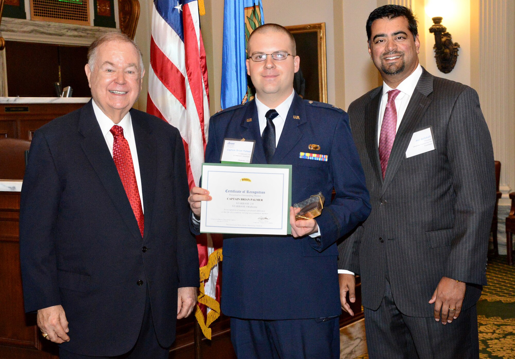 Capt. Brian Palmer, with the Air Force Life Cycle Management Center, received a certificate of recognition for being an outstanding mentor with Starbase 2.0 at Oklahoma Mentor Day at the state Capitol on Jan. 8. Presenting the award were the University of Oklahoma President and founder of the Oklahoma Foundation for Excellence David O. Boren, left, and the Oklahoma Foundation for Excellence President Anil Gollahalli. Captain Palmer volunteers his time with the Advanced Science and Technology Charter School after-school club, helping the students with STEM-focused projects. (Air Force photo by Kelly White/Released)