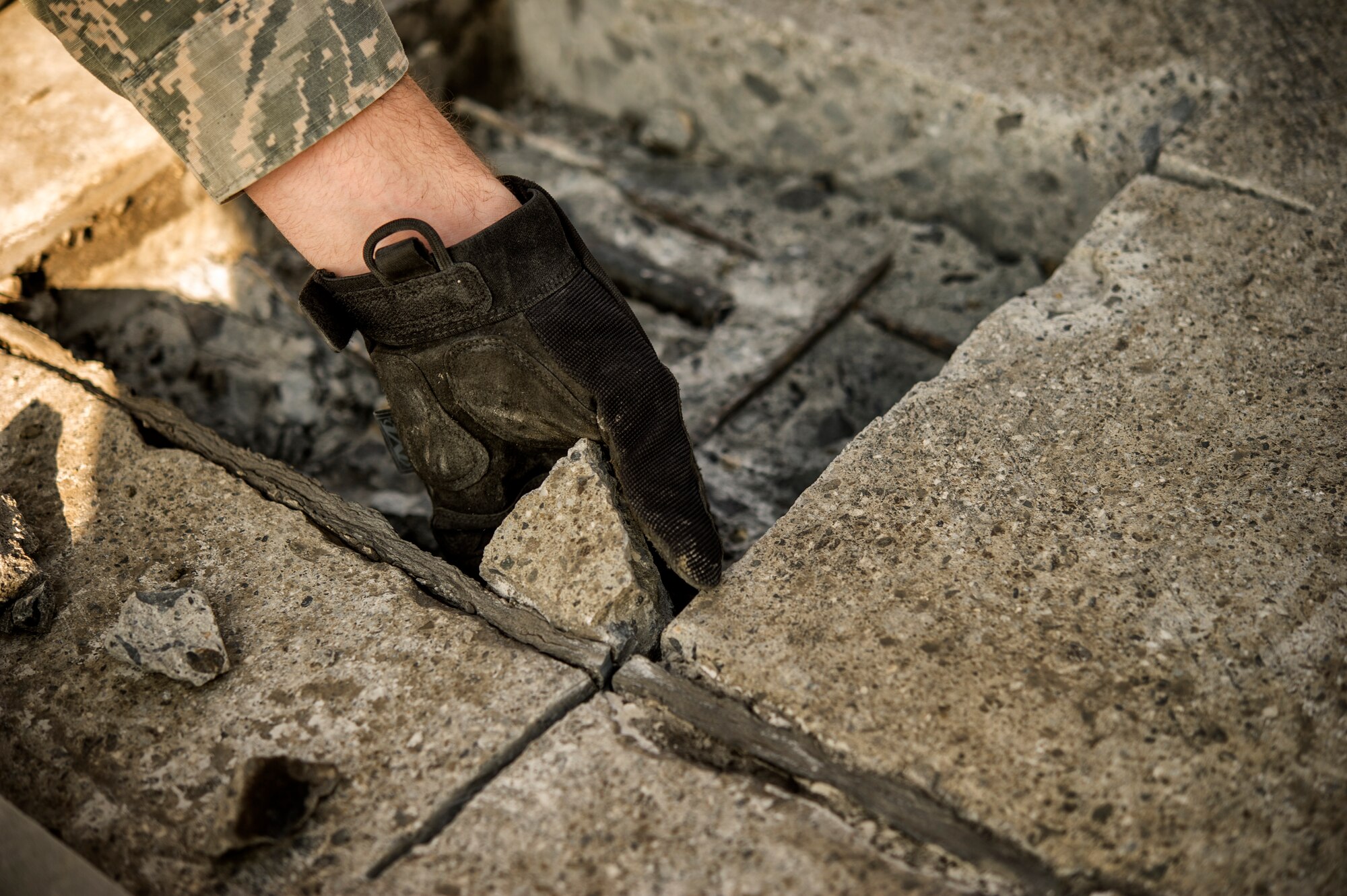 Airman 1st Class Connor Harrington, 374th Civil Engineer Squadron pavement and equipment apprentice, removes a section of concrete from a spall repair site on Yokota Air Base, Japan, Jan. 13, 2016. Aptly named ‘Dirt Boys’, 374 CES pavement and equipment Airmen perform spall repairs as part of their preventative maintenance practices to ensure Yoktoa’s airfield is free of cracks and tears. (U.S. Air Force photo by Airman 1st Class Delano Scott/Released)