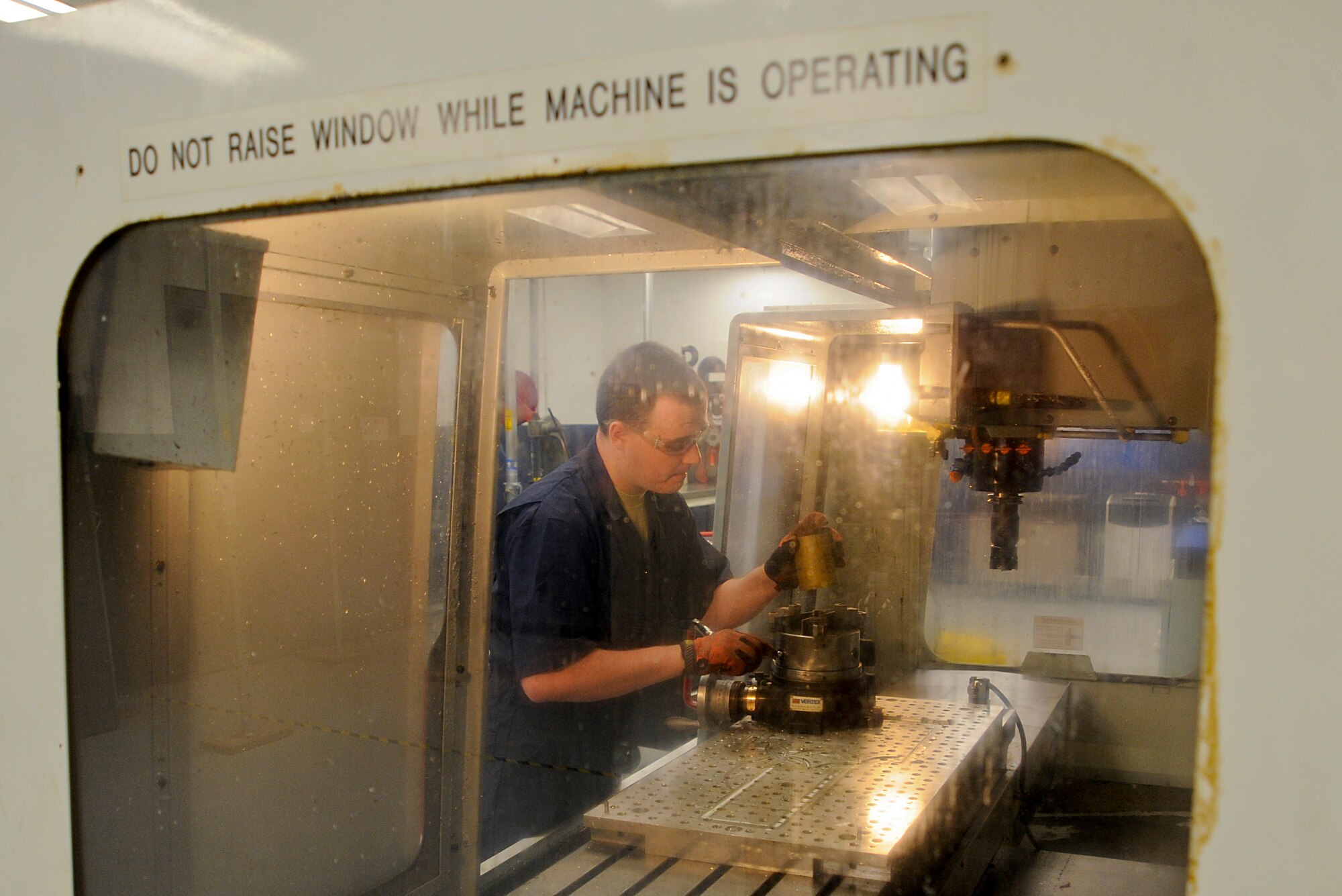Airman 1st Class Brandon Gentry, an aircraft metals technology technician with the 6th Maintenance Squadron, mounts stock, a large piece of metal, into a computer numerical control machine at MacDill Air Force Base, Fla., Jan. 6, 2016. Metals technology technicians are responsible for fixing and fabricating parts using welding and machinery. (U.S. Air Force photo by Airman 1st Class Mariette M. Adams)