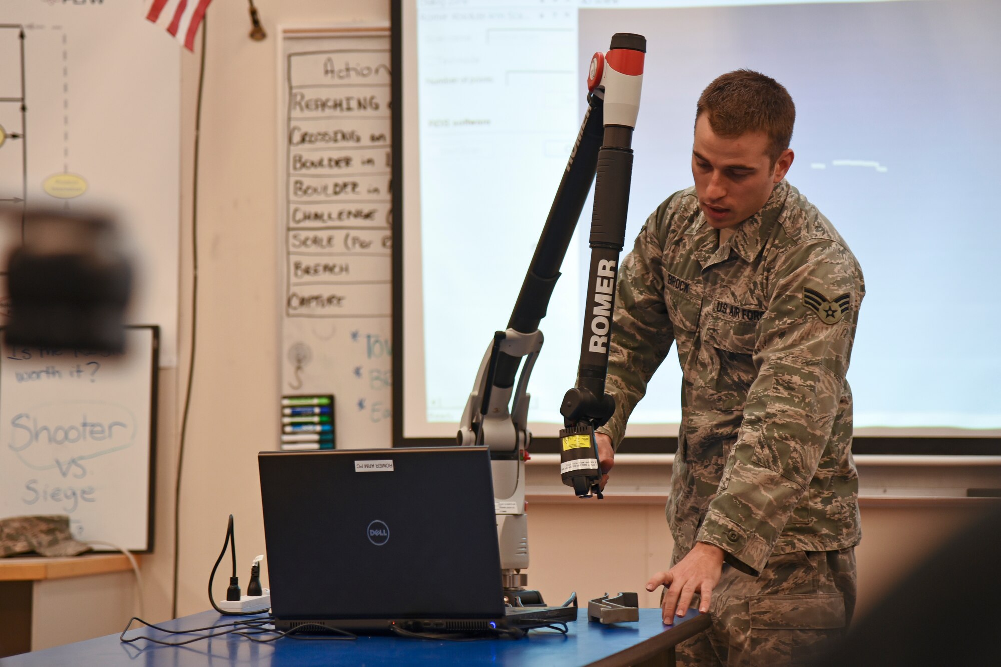 Senior Airman Jerry Brock, 92nd Maintenance Squadron metals technology craftsman, demonstrates the abilities of the Romer Absolute Arm to engineering and mechanics students Jan. 13, 2016, at Medical Lake High School, Medical Lake, Wash. The demonstration helped students make the connection between their computer-aided drafting classes and using their knowledge in the real world. (U.S. Air Force photo/Airman 1st Class Mackenzie Richardson)
