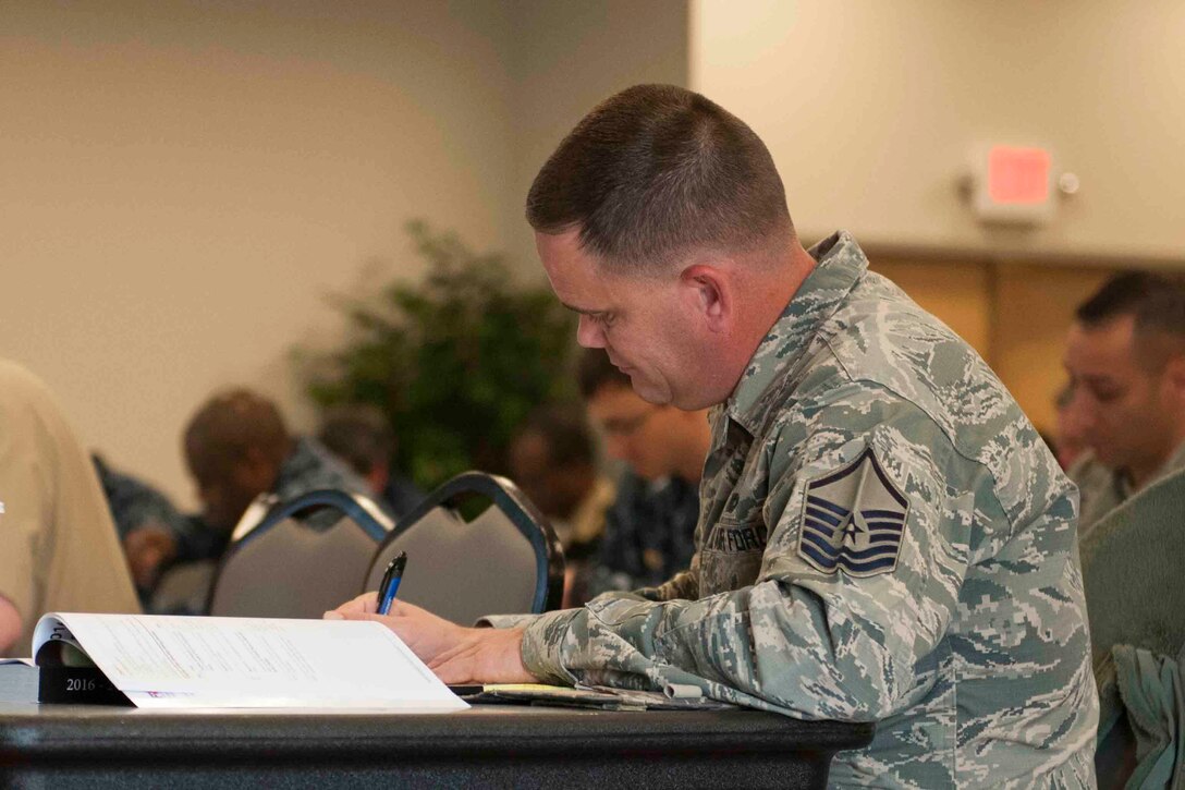 Master Sgt. Todd Striplin, 11th Security Forces Group voting assistant representative, fills out a Federal Post Card Application during a Voting Assistance Workshop at Joint Base Andrews, Md., Jan. 12, 2016. The workshop, run by the Federal Voting Assistance Program, trained more than 50 Department of Defense members on providing assistance to service members and their families during the voting process. (U.S. Air Force photo by Senior Airman Dylan Nuckolls/Released)