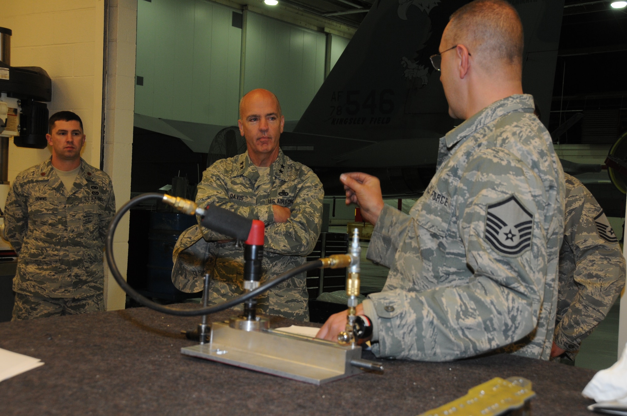 U.S. Air Force Master Sgt. David Chinander, 173rd Maintenance Group, explains to Maj. Gen. T. Glenn Davis, the mobilization assistant to the commander, Air Force Life Cycle
Management Center, how a tool designed and fabricated locally in the 173rd Sheet Metal shop helps save lost sorties, manpower and perhaps millions of dollars. Without this fixture an aircraft has to go to depot maintenance in Georgia incurring those costs and removing it from the fleet until it returns. (U.S. Air National Guard photo by Master Sgt. Jennifer Shirar)