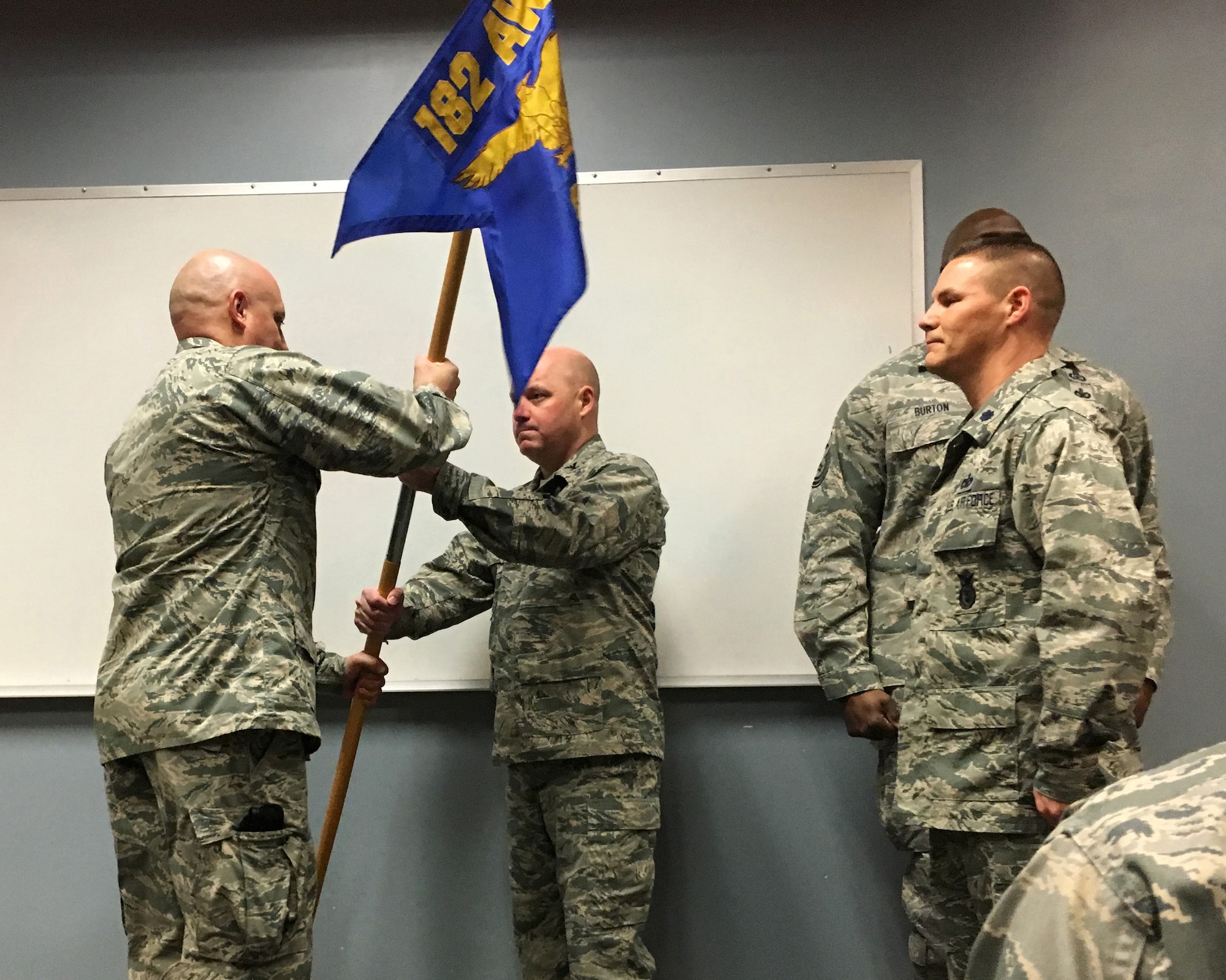 Maj. Gary Velasquez, left, accepts the 182nd Security Forces Squadron guidon from Col. Cory Reid, commander of the 182nd Mission Support Group, during a change of command Jan. 9, 2016. At right is Lt. Col. Todd Leach, outgoing Security Forces Squadron commander. (Air National Guard photo by Master Sgt. Blake Pumphrey) 