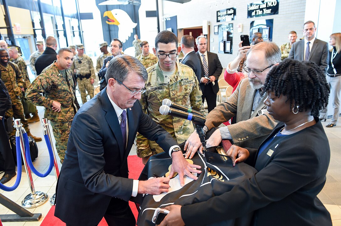 Defense Secretary Ash Carter signs a 101st Airborne Division flag on Fort Campbell, Ky., Jan. 13, 2016, for a soldier who will deploy to Iraq later this year. DoD photo by Army Sgt. 1st Class Clydell Kinchen
