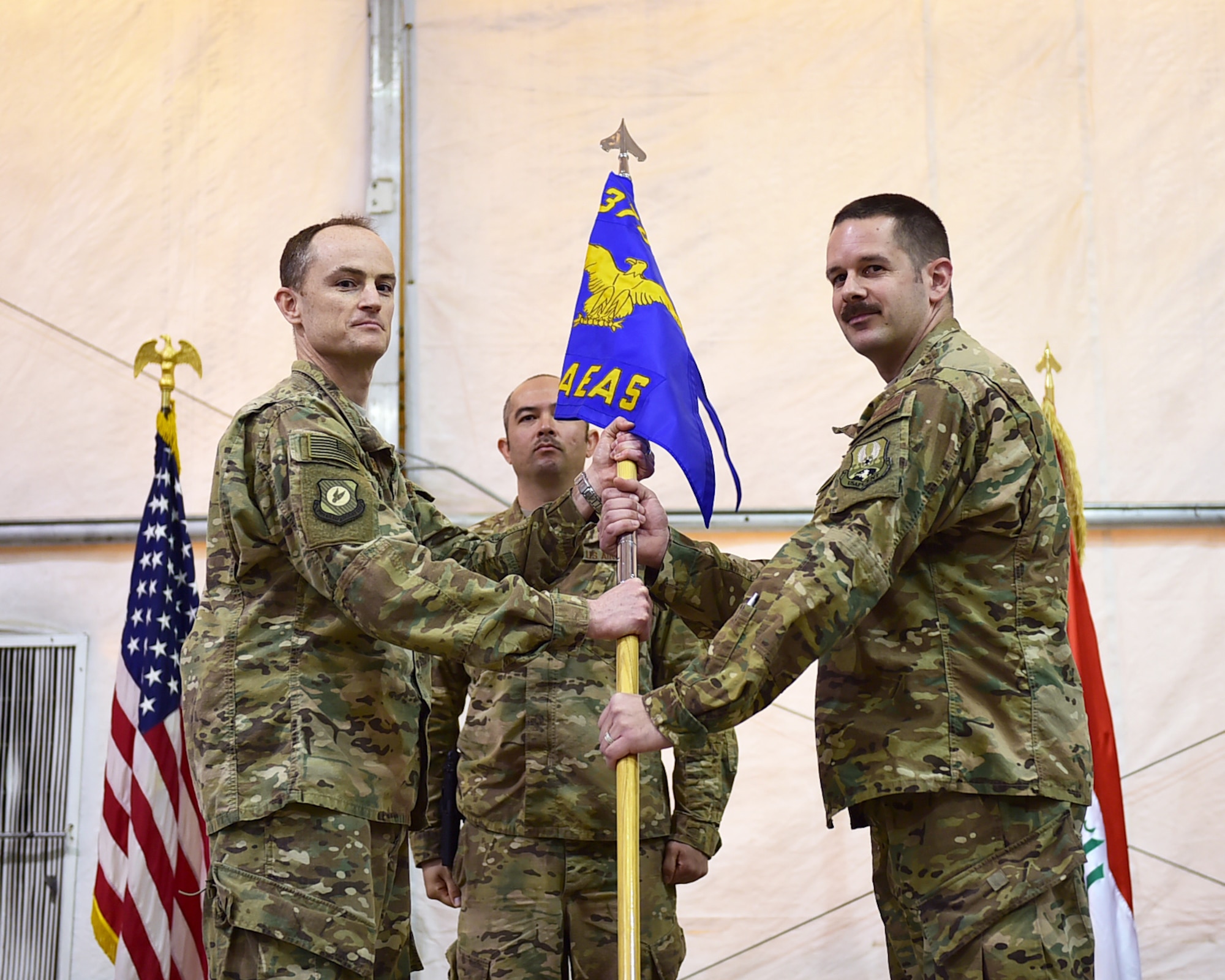 Col. Bradley Bridges, 370th Air Expeditionary Advisory Group commander, hands the 770th Air Expeditionary Advisory Squadron guidon to Maj. Todd Meyers during a change of command ceremony in Baghdad, Iraq, Jan. 9, 2016. Prior to assuming command of the 770th AEAS, Meyers served as the 911th Maintenance Squadron commander based in Pittsburgh International Airport Air Reserve Station, Coraopolis, Pennsylvania. The 770 AEAS provides direct support to the Iraqi Air Force through aircraft maintenance advise and assist missions.  (U.S. Air Force photo by Staff Sgt. Jerilyn Quintanilla)