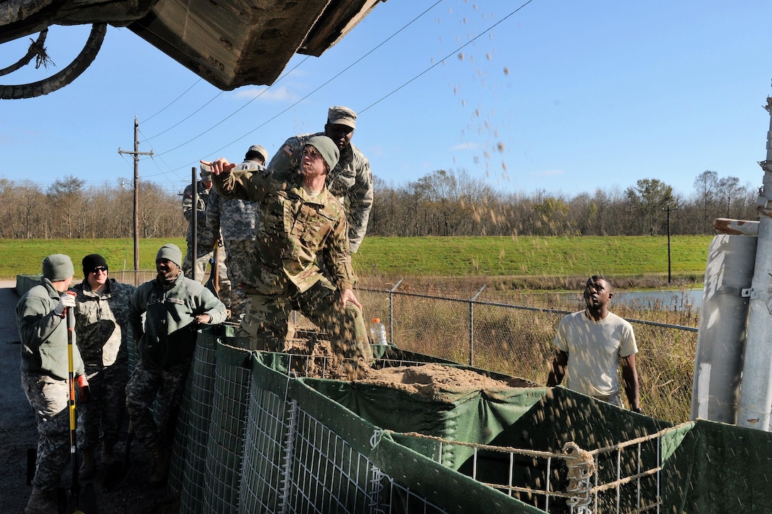 Soldiers fill barriers while building a levee to support Operation Winter River Flooding in Krotz Springs, La. Jan. 10, 2016. Louisiana National Guard photo by Army Staff Sgt. Greg Stevens
