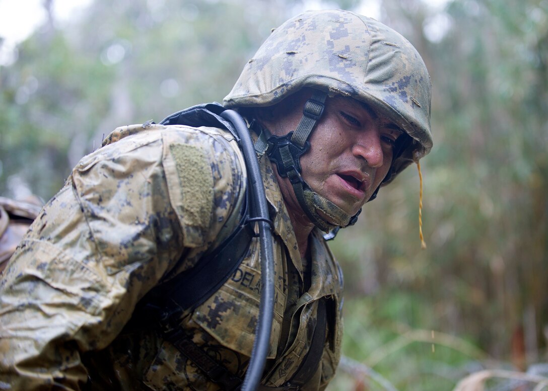 U.S. Navy Petty Officer 2nd Oscar C. Delarosa gasps for air after crawling through muddy trenches during a 3.8-mile obstacle course at the Jungle Warfare Training Center in Okinawa, Japan, Jan. 12, 2016. Delarosa is assigned to Naval Mobile Construction Battalion 3. U.S. Navy photo by Petty Officer 1st Class Michael Gomez
