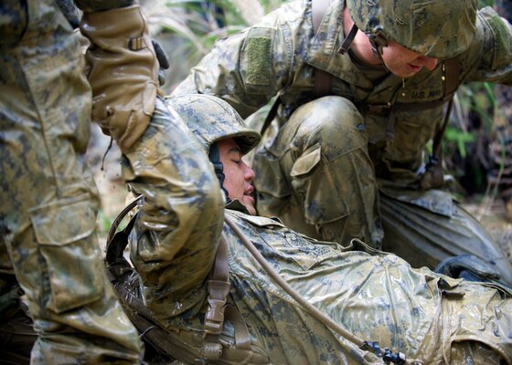 U.S. sailors work together to exit a mud-filled trench during a jungle warfare training evolution at the Jungle Warfare Training Center in Okinawa, Japan, Jan. 12, 2016. U.S. Navy photo by Petty Officer 1st Class Michael Gomez