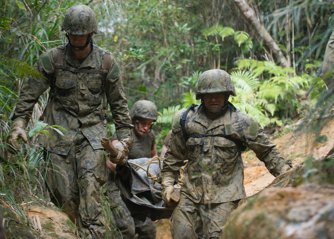 U.S. Sailors carry a mock casualty on an improvised stretcher while running a six-hour endurance course at the Marine Corps Jungle Warfare Training Center in Okinawa, Japan, Jan. 12, 2016. The sailors are assigned to Naval Mobile Construction Battalion 3. U.S. Navy photo by Petty Officer 1st Class Michael Gomez