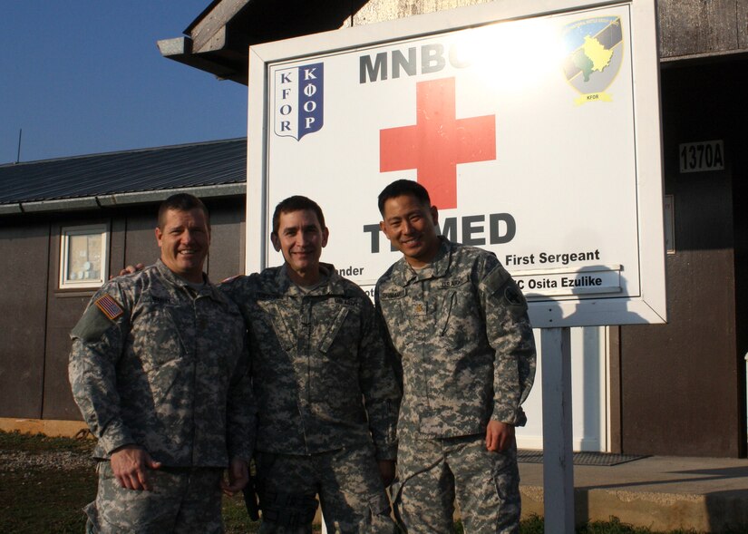 U.S. Army Maj. David Whaley, Col. Edward Perez-Conde, and Maj. Kirk Shimamoto pose outside their Task Force Medical headquarters, Dec. 15, 2015, which serves as the installation hospital at Camp Bondsteel, Kosovo. The three U.S. Army Reserve officers responded to a civilian's life-threatening injuries during a four-day pass in Athens, Greece. Hailing from the 345th Combat Support Hospital in Florida, 308th Civil Affairs Brigade in Illinois, and 7234th Medical Support Unit in California, the three served as members of Multinational Battle Group-East and part of NATO's Kosovo Force mission in the Balkans. (U.S. Army photo by Lt. Col. Gilbert Buentello, Multinational Battle Group-East)