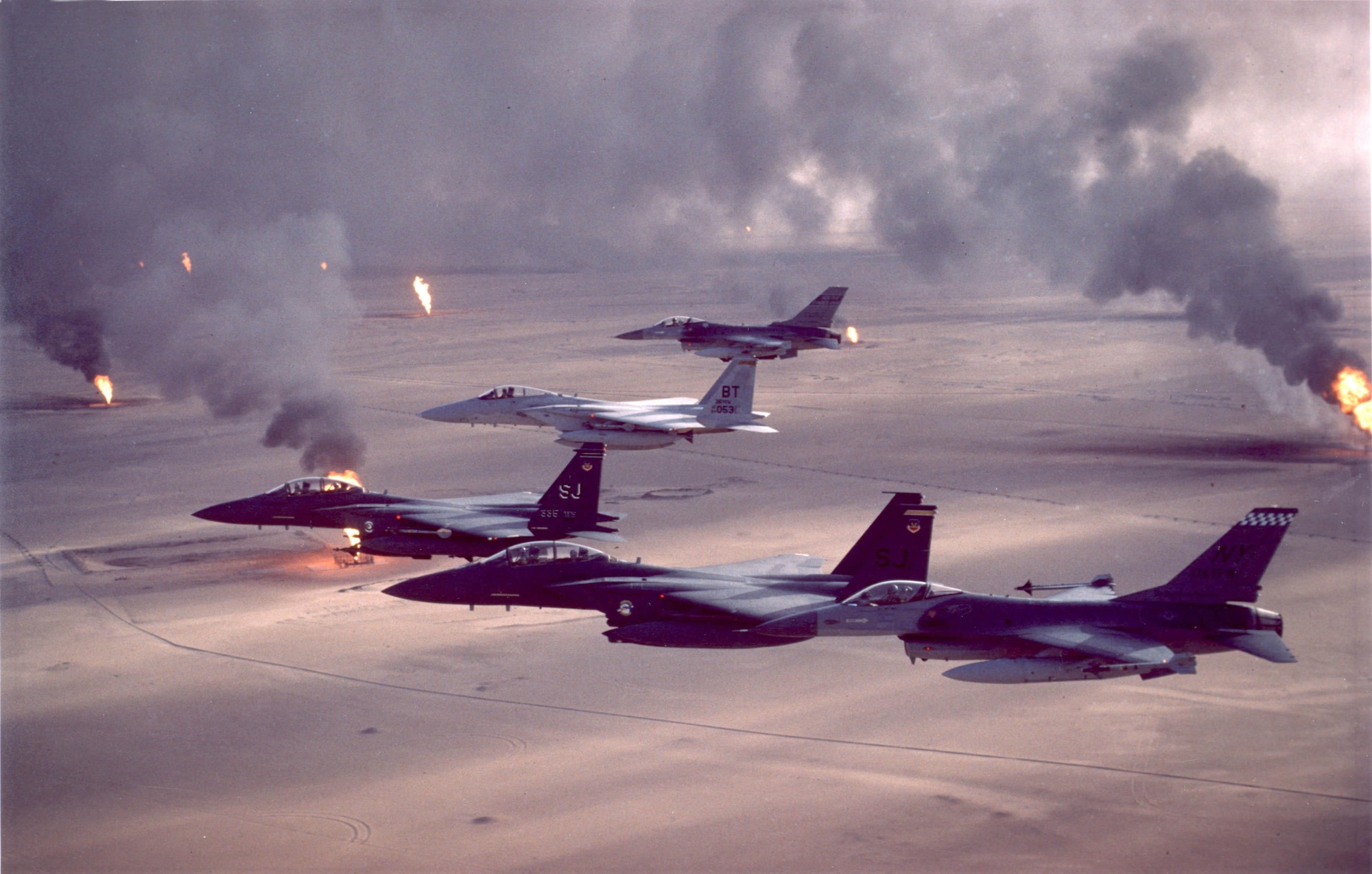 F-16A Fighting Falcon, F-15C Eagle and F-15E Strike Eagle fighter aircraft fly over burning oil field sites in Kuwait during Operation Desert Storm. (U.S. Air Force archive photo)