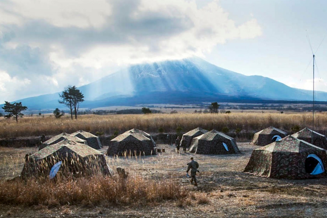 A Marine heads for his tent below Mt. Fuji during Exercise Fuji Samurai on Combined Arms Training Center Camp Fuji, Gotemba, Japan,  Jan. 7, 2016. Exercise Fuji Samurai is held in January and includes numerous fire and maneuver drills and other combat-based training events. U.S. Marine Corps photo by Cpl. Janessa Pon