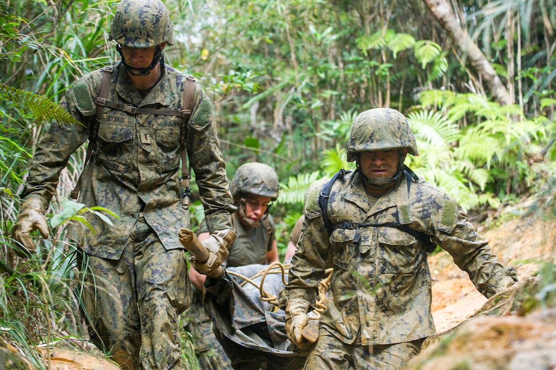 Seabees carry a mock casualty on an improvised stretcher through the jungle while running a six-hour endurance course at the Marine Corps Jungle Warfare Training Center in Okinawa, Japan, Jan. 12, 2016. A total of 49 Seabees from Naval Mobile Construction Battalion 3 attended the five-day course. U.S. Navy photo by Petty Officer 1st Class Michael Gomez