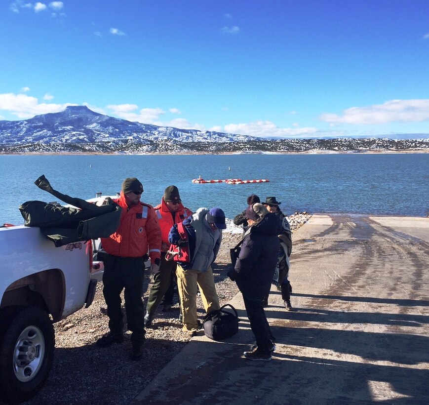 ABIQUIU LAKE, N.M. – Project Manager John Mueller and Lead Park Ranger Austin Kuhlman hand out life jackets to some of the volunteers before they get on a boat to count eagles, Jan. 9, 2016. 