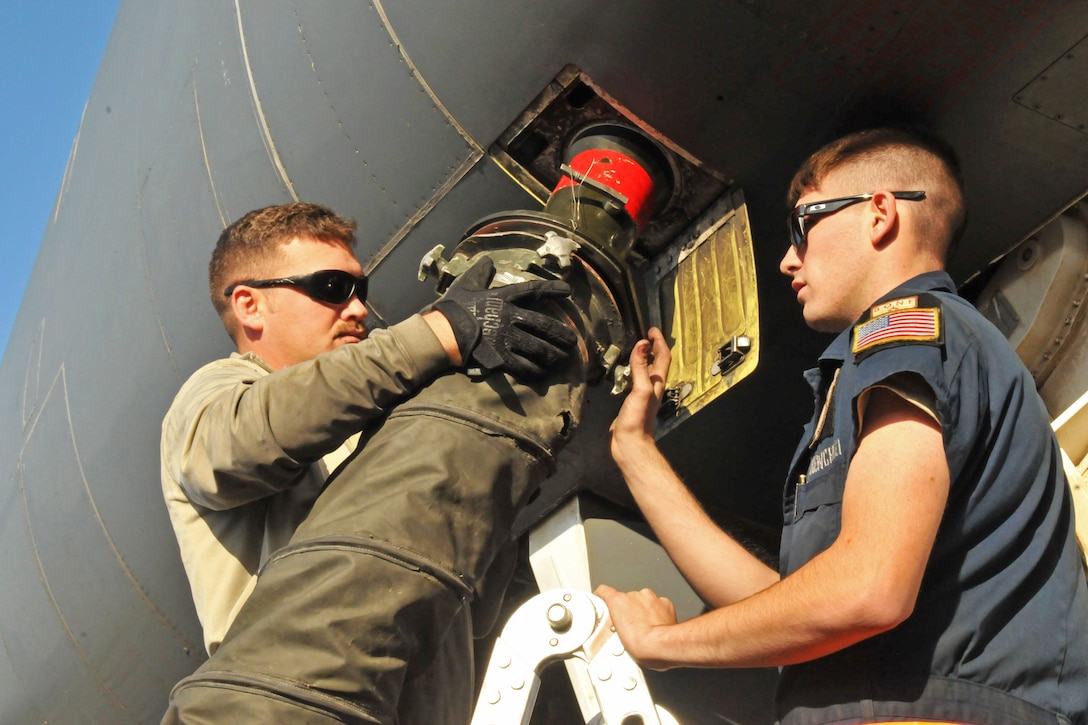 U.S. Air Force Senior Airman Brandon Wilkins, left, and Airman 1st Class Jacob Shores perform a post-flight inspection on a B-1B Lancer on Al Udeid Air Base, Qatar, Jan. 11, 2016. Wilkins and Shores, maintainers deployed from Ellsworth Air Force Base, S.D., hook up power and air to the B-1 which allows the jet to stay cool while it receives gas. U.S. Air Force photo by Tech. Sgt. Terrica Y. Jones