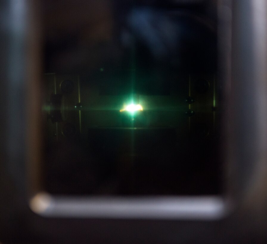 Green light illuminates inside a spectrometer as oil burns during a joint oil analysis program inspection, Jan. 12, 2016, at Moody Air Force Base, Ga.  The JOAP is a Department of Defense program which samples oil from aircraft and measures certain elements and intensity of light in order to determine if there are metal wears in the engines. (U.S. Air Force photo by Airman 1st Class Greg Nash/Released) 