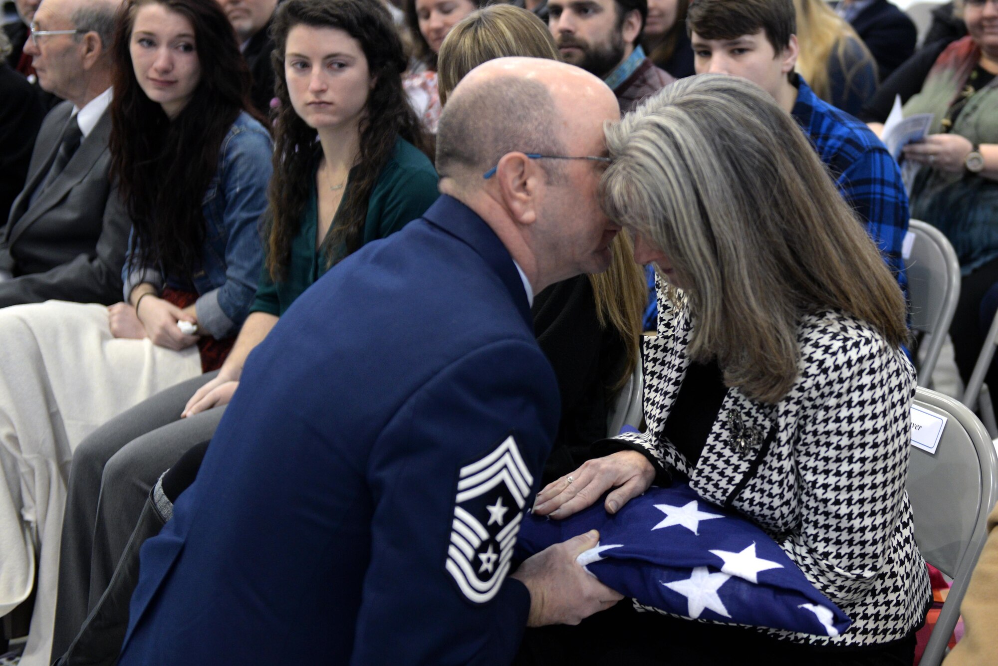 Chief Master Sgt. Jeffrey Craver, 4th Fighter Wing command chief, hands an American flag to his wife, Kelley, during his retirement ceremony, Jan. 15, 2016, at Seymour Johnson Air Force Base, North Carolina. In his speech, Craver gave thanks to his wife and three daughters for their love and support throughout his 30 year career. (U.S. Air Force photo/Airman 1st Class Ashley Williamson)