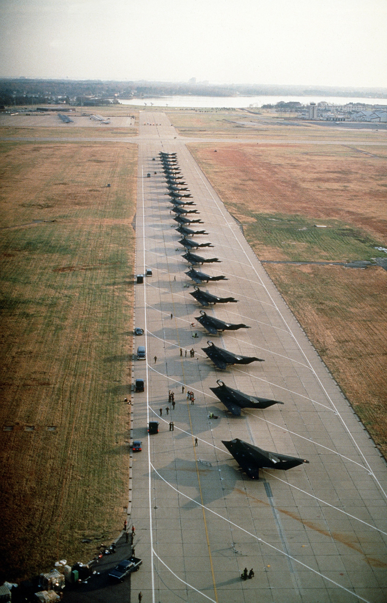 U.S. Air Force F-117A Nighthawk stealth fighter aircraft from the 37th Tactical Fighter Wing, Tonopah Test Range, Nevada, line the runway while deploying to Saudi Arabia during Operation Desert Shield. (U.S. Air Force Courtesy Photo)