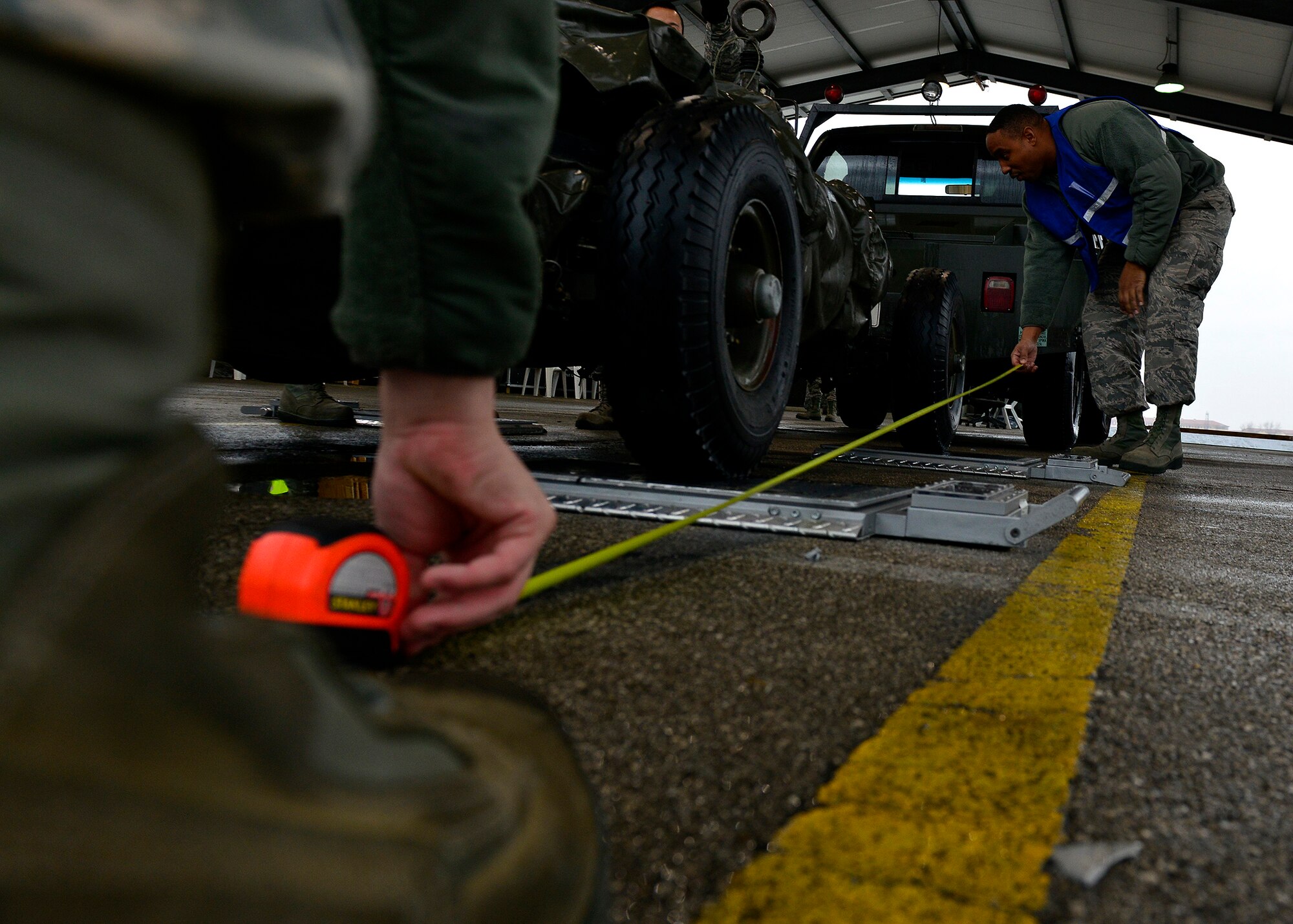 U.S. Air Force Tech. Sgt. Damian Anderson, 31st LRS personal property NCO in charge, helps measure the length of a trailer during a cargo inspection, Jan. 11, 2016, at Aviano Air Base, Italy. The cargo was secured, inspected, and prepared by several teams before it was loaded for shipment to Nellis Air Force Base, Nevada. (U.S. Air Force photo by Airman 1st Class Cary Smith/Released)