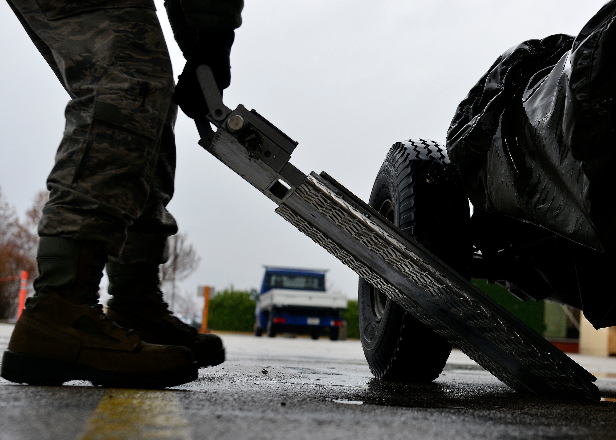 A U.S. Air Force Airman places a weight scale under a trailer during a cargo inspection, Jan. 11, 2016, at Aviano Air Base, Italy. Several Logistics Readiness Squadron teams weighed, measured, and quality-checked every piece of equipment before it was loaded for shipment to Nellis Air Force Base, Nevada. (U.S. Air Force photo by Airman 1st Class Cary Smith/Released)