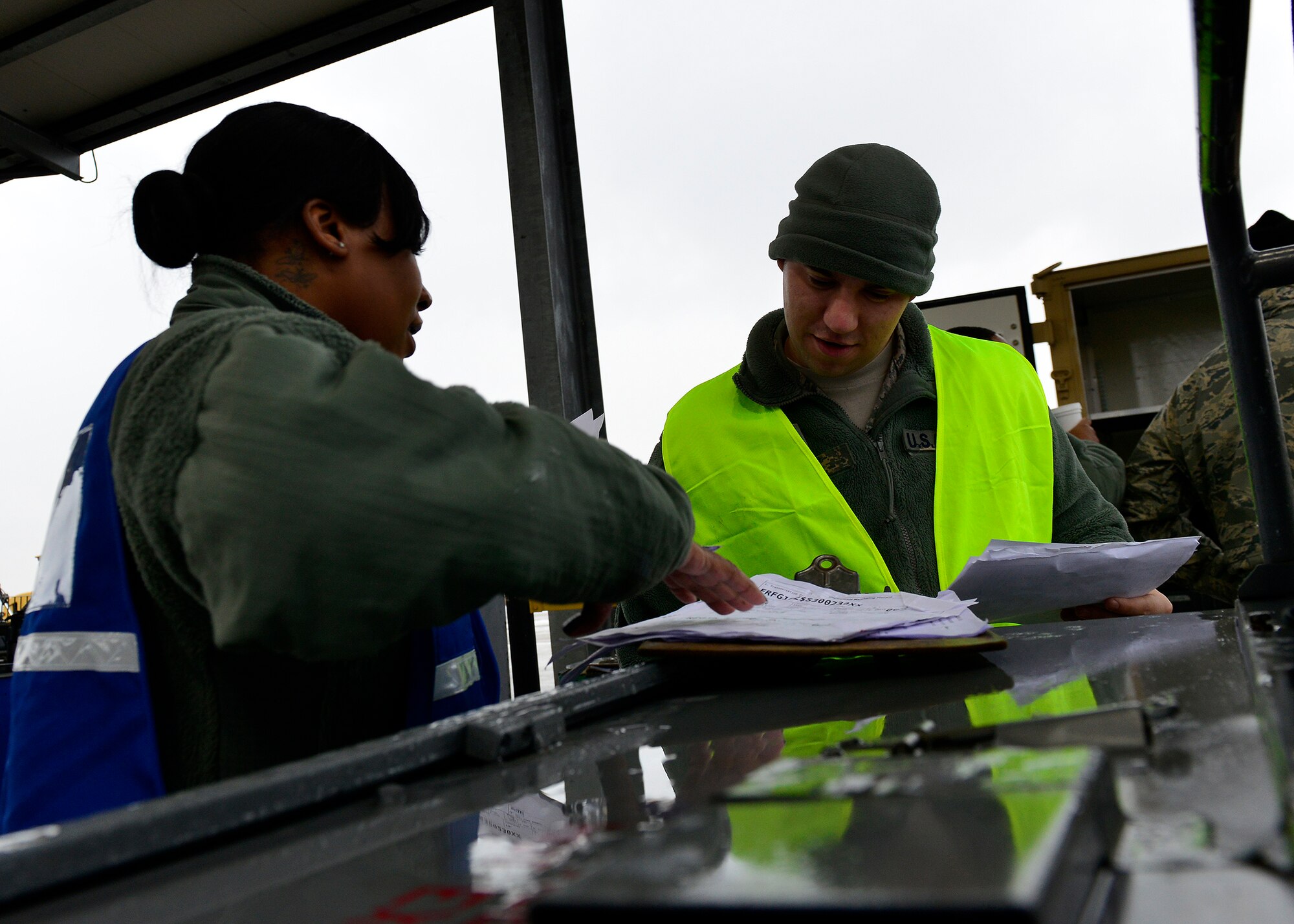 (From left) U.S. Air Force Tech. Sgt. Nashan Jalivay-Pereira, 31st Logistics Readiness Squadron outbound cargo NCO in charge, and Senior Airman Lucas Jelinek, 31st LRS inbound cargo journeyman, verify paperwork during a cargo inspection, Jan. 11, 2016, at Aviano Air Base, Italy. The cargo was secured, inspected, and prepared by several teams before it was loaded for shipment to Nellis Air Force Base, Nevada. (U.S. Air Force photo by Airman 1st Class Cary Smith/Released)