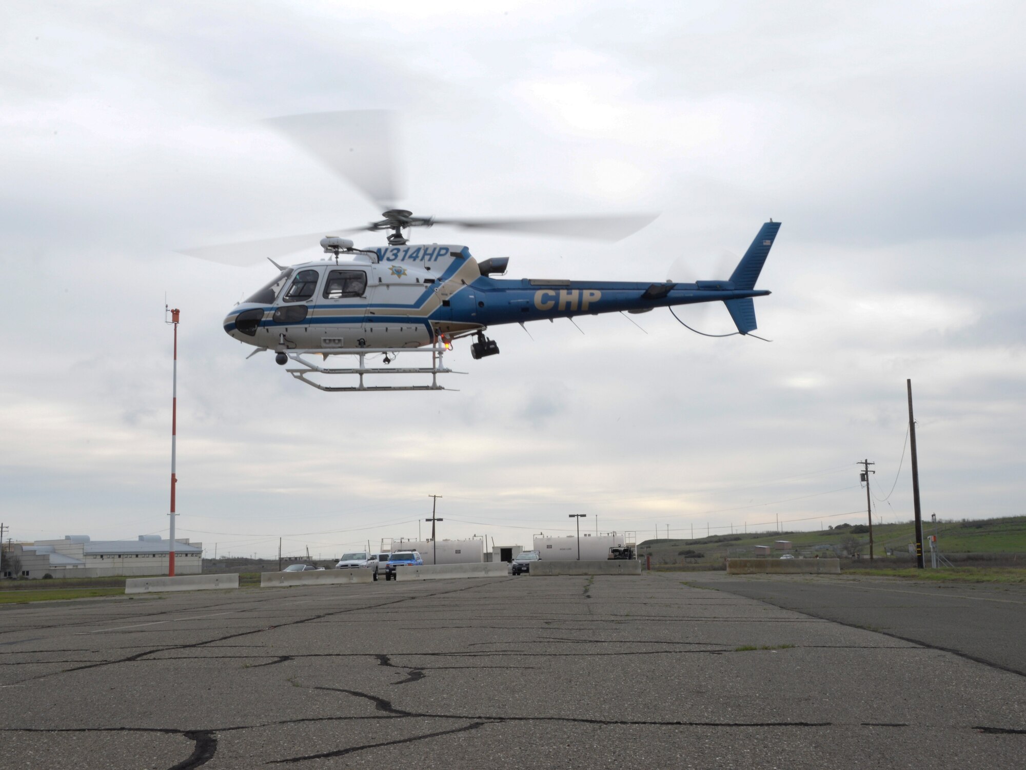 A CHP helicopter carrying a military working dog and his handler ascends Jan. 11 at Travis Air Force Base, California. After exiting the helicopter, the MWDs took part in a training scenario involving detection of illegal substances. (U.S. Air Force photo by Airman 1st Class Amber Carter)