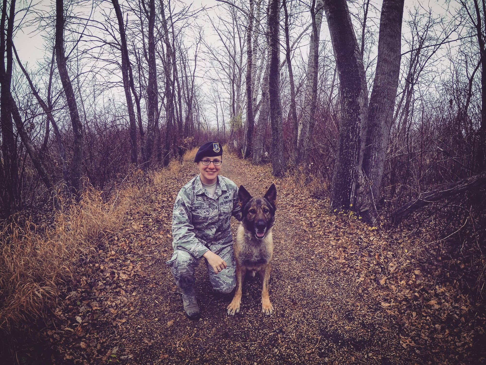 Senior Airman Sara Yandell, 319th Security Forces Squadron military working dog handler, poses for a photo with her dog Atti. Yandell said her love of nature keeps her grounded while her wife is deployed. (Courtesy photo taken by Senior Airman Sara Yandell)