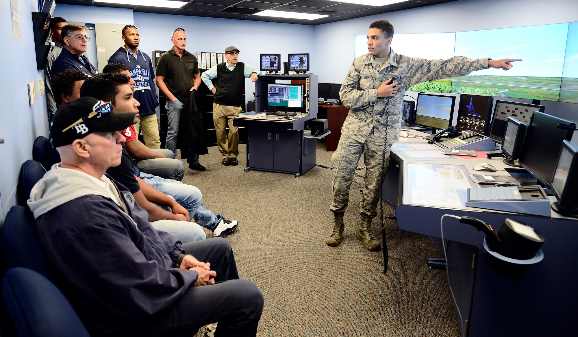 Airman 1st Class Kevin Beasley, an air traffic controller assigned to the 6th Operations Support Squadron, points to an aircraft on an ATC simulator during a base tour at MacDill Air Force Base, Fla., Jan. 12, 2016. Players and staff from the Rays spent the afternoon with Airmen to get an inside look at MacDill’s mission. (U.S. Air Force photo by Senior Airman Tori Schultz)