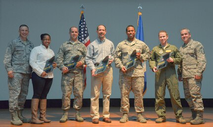 Colonel John Lamontagne, 437th Airlift Wing commander (far left), and Chief Master Sgt. Kristopher Berg, 437th AW command chief (far right), stand with the awardees from the 437th AW quarterly awards ceremony at the Air Base Theater on Joint Base Charleston – Air Base, S.C., on Jan. 14, 2016. From left to right the recipients are Tiffany Gamble, 437th Maintenance Squadron unit program coordinator, for the civilian category I award, MSgt. Trapper Otto, 437th MXS hydraulic section chief, for the senior non-commissioned officer award, Gary Wettengel, 437th Operations Support Squadron, combat tactics aircraft weapons specialist, for the category civilian II award, Capt. Ryan Nichols, 437th OSS airfield operations flight commander, for the company grade officer award and TSgt. David Flory, 16th Airlift Squadron operations support flight chief, for the non-commissioned officer award. Senior Airman Gloria Davis-Phillips, 437th Maintenance Group aircraft maintenance unit analyst, won the  Airman of the quarter award but was not present to receive it personally. (U.S. Air Force photo/Airman 1st Class Thomas T. Charlton)