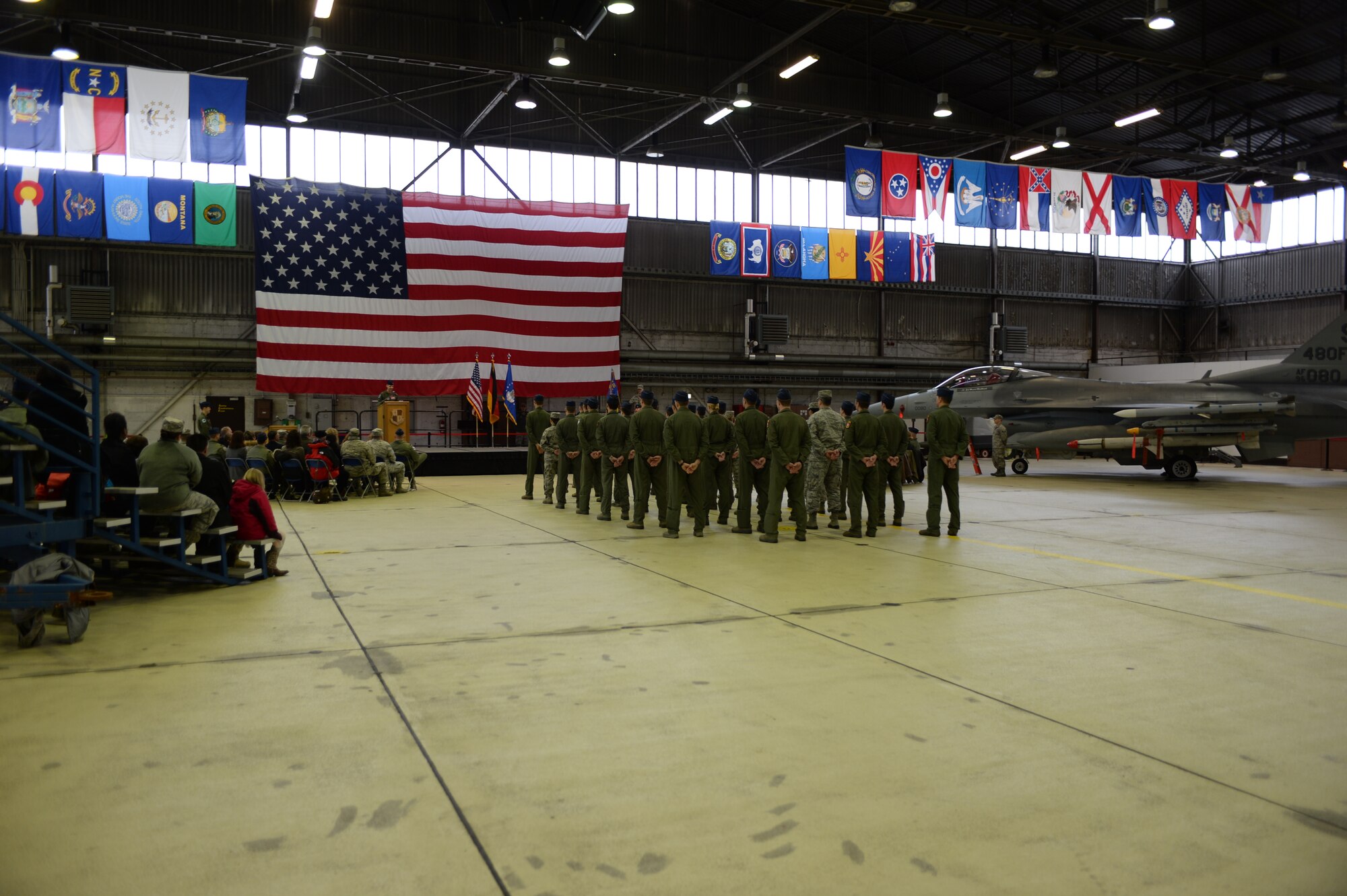 Spangdahlem Air Base community members watch the 480th Fighter Squadron change of command ceremony at Hangar One on Spangdahlem Air Base, Germany, Jan. 15, 2016. The ceremony included the presentation of the colors by the Spangdahlem Air Base Honor Guard and the singing of the German and American national anthems by the Singing Sabers organization. (U.S. Air Force photo by Staff Sgt. Joe W. McFadden/Released)