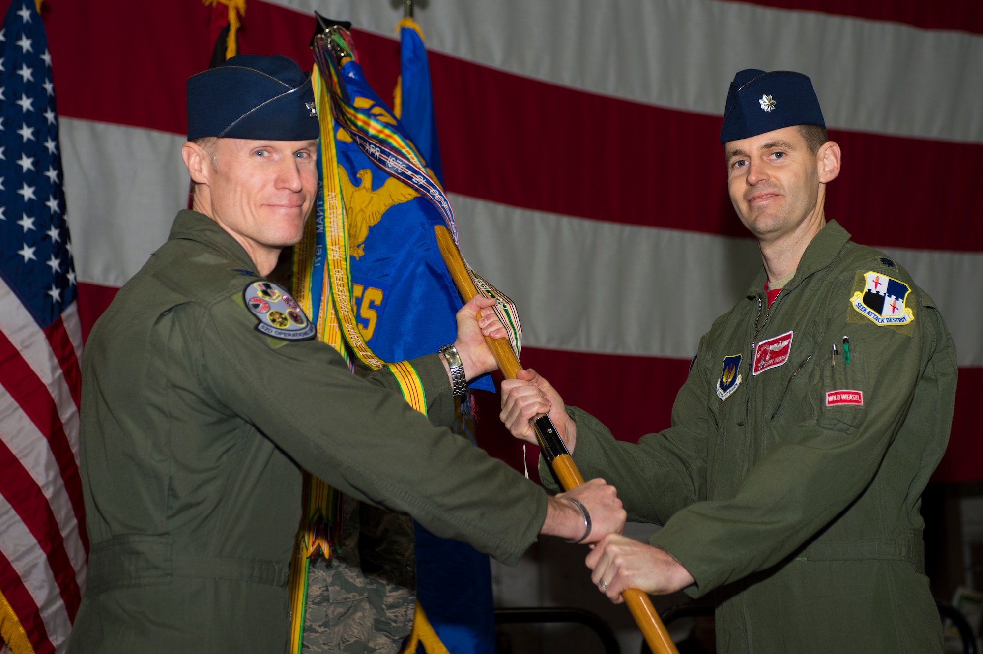 U.S. Air Force Col. Michael Thompson, 52nd Operations Group commander, left, passes a guidon to U.S. Air Force Lt. Col. Timothy Murphy, 480th Fighter Squadron commander, during a change of command ceremony at Hangar One on Spangdahlem Air Base, Germany, Jan. 15, 2016. Murphy assumed command from outgoing commander U.S. Air Force Lt. Col. David Berkland. (U.S. Air Force photo by Staff Sgt. Joe W. McFadden/Released)