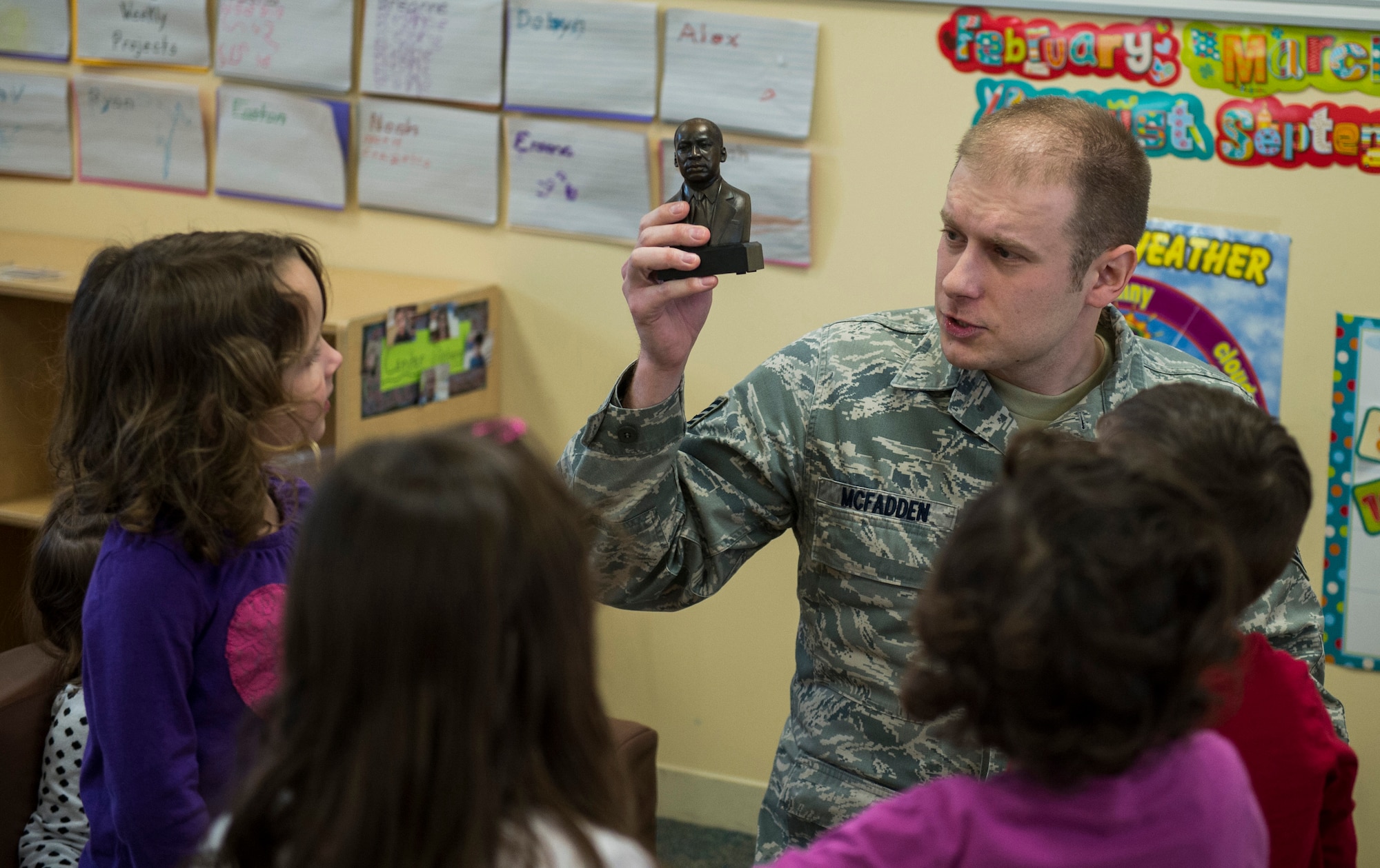 U.S. Air Force Staff Sgt. Joe McFadden, 52nd Fighter Wing Public Affairs photojournalist, displays a miniature statue of Dr. Martin Luther King Jr. to a group of children at the Child Development Center on Spangdahlem Air Base, Germany, Jan. 14, 2016. McFadden, Airmen Against Drunk Driving president, sponsored the third annual Dr. Martin Luther King Jr. ‘Reading Is A Civil Right’ reading drive to promote early literacy among children ahead of the holiday weekend. (U.S. Air Force photo by Airman 1st Class Luke Kitterman/Released) 