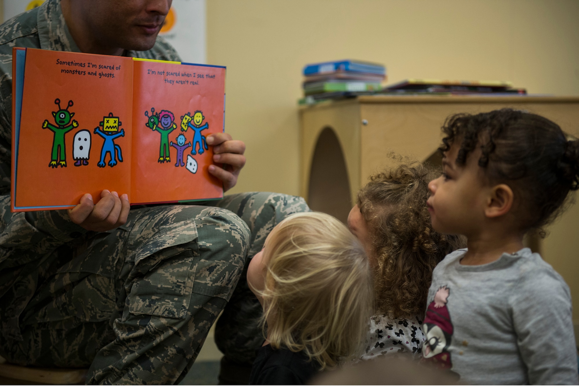U.S. Air Force Master Sgt. Roberto Oregon, Pitsenbarger Airman Leadership School commandant, holds a book open during the third annual Dr. Martin Luther King Jr. ‘Reading Is A Civil Right’ reading drive at the Child Development Center on Spangdahlem Air Base, Germany, Jan. 14, 2016. More than 40 volunteers read to children from Jan. 13-15 to promote early literacy among children ahead of the holiday weekend. (U.S. Air Force photo by Airman 1st Class Luke Kitterman/Released) 