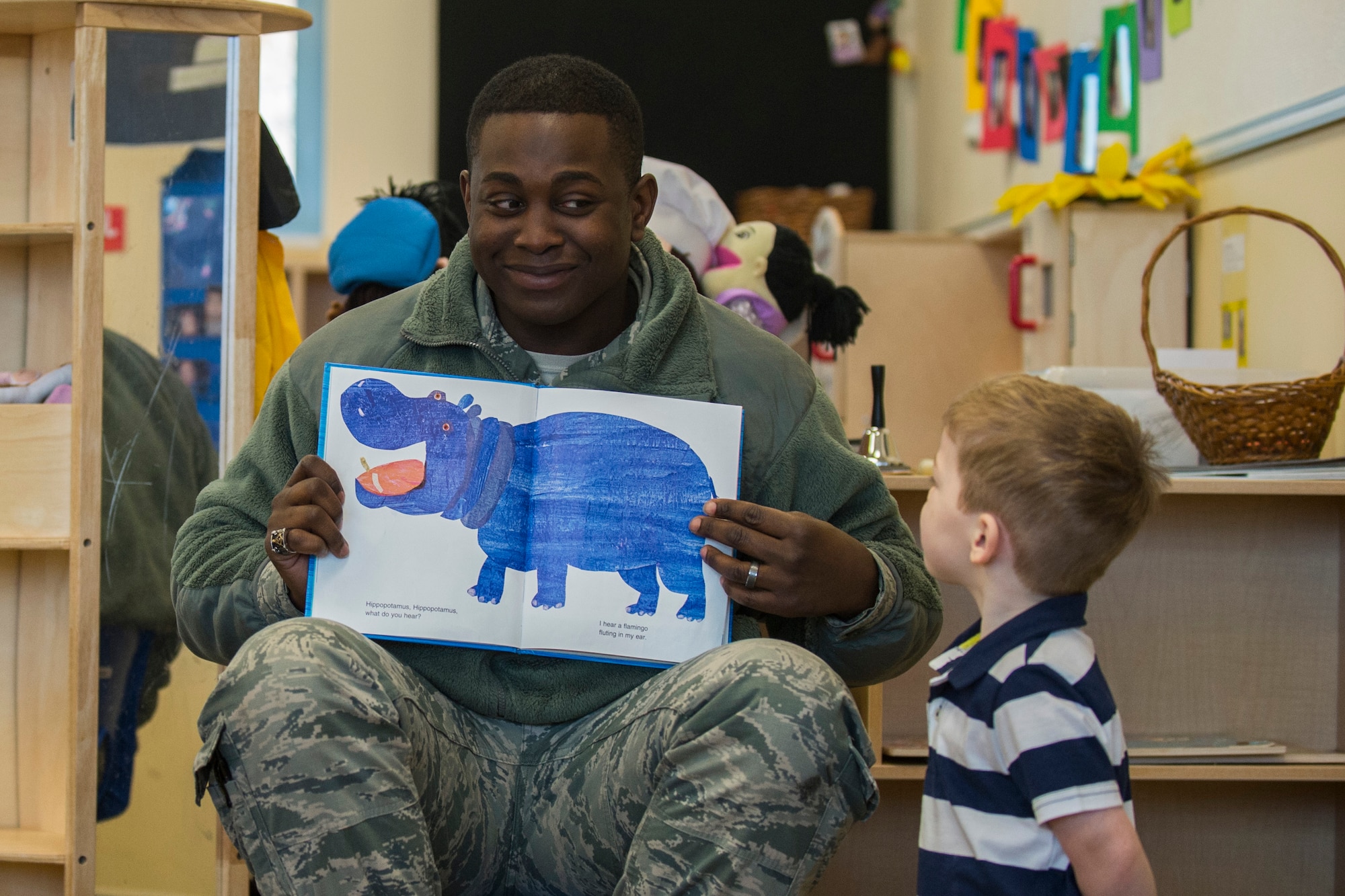 U.S. Air Force Senior Airman Emanuel Jordan, a 52nd Security Forces Squadron member, smiles at a child during the third annual Dr. Martin Luther King Jr. ‘Reading Is A Civil Right’ reading drive at the Child Development Center on Spangdahlem Air Base, Germany, Jan. 14, 2016. The CDC welcomed volunteers to read to children between the ages of 1 and 5. (U.S. Air Force photo by Airman 1st Class Luke Kitterman/Released) 