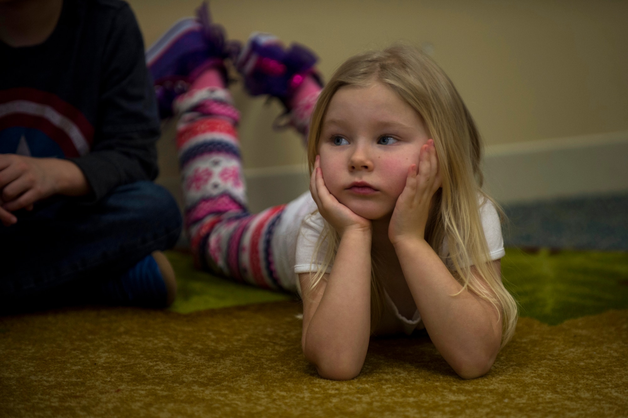 A child listens during the third annual Dr. Martin Luther King Jr. ‘Reading Is A Civil Right’ reading drive at the Child Development Center on Spangdahlem Air Base, Germany, Jan. 14, 2016. More than 40 volunteers read to children from Jan. 13-15 to promote early literacy among children ahead of the holiday weekend. (U.S. Air Force photo by Airman 1st Class Luke Kitterman/Released) 