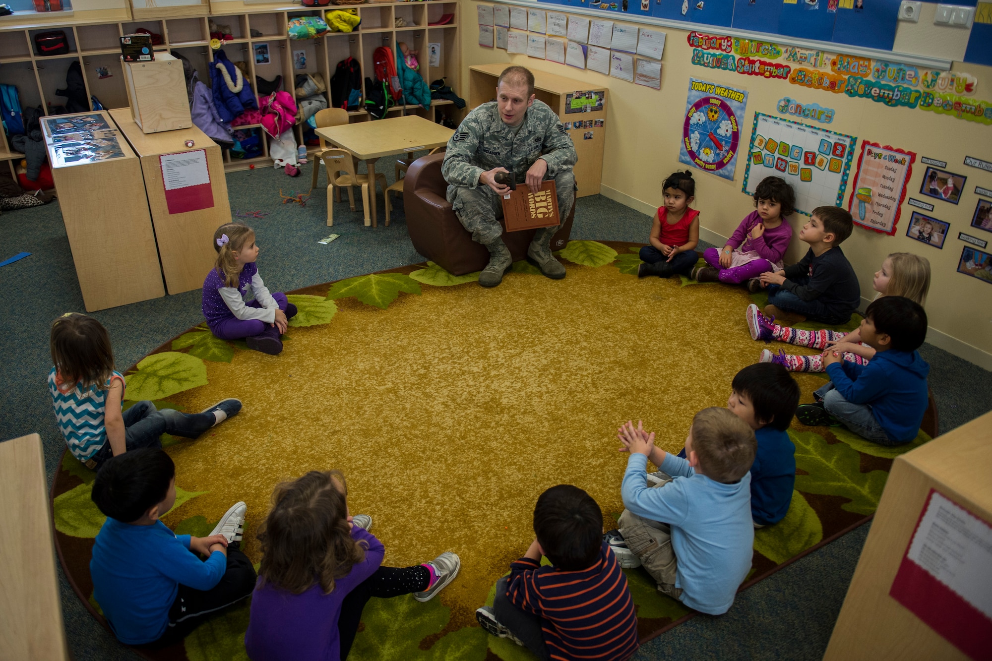 U.S. Air Force Staff Sgt. Joe W. McFadden, a 52nd Fighter Wing Public Affairs photojournalist, talks to a group of children before reading to them at the Child Development Center on Spangdahlem Air Base, Germany, Jan. 14, 2016. McFadden, Airmen Against Drunk Driving president, sponsored the third annual Dr. Martin Luther King Jr. ‘Reading Is A Civil Right’ reading drive to promote early literacy among children ahead of the holiday weekend. (U.S. Air Force photo by Airman 1st Class Luke Kitterman/Released) 
