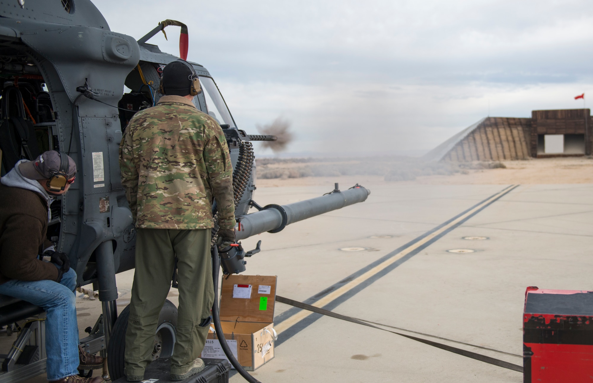 An Air Force HH-60G Pave Hawk helicopter fires its GAU-21 .50 caliber machine gun at Edwards AFB's Gun Harmonizing Range Jan. 13. The testing is part of the Air Combat Command's HH-60 Defensive Weapons System Upgrade modification proposal. The modification proposal requires the new weapon to be an open bolt system, have a longer barrel life, a higher cyclic rate of fire, be lighter weight and have reduced recoil. The selected weapon must also be used currently by other Department of Defense services. (U.S. Air Force photo by Brad White)

