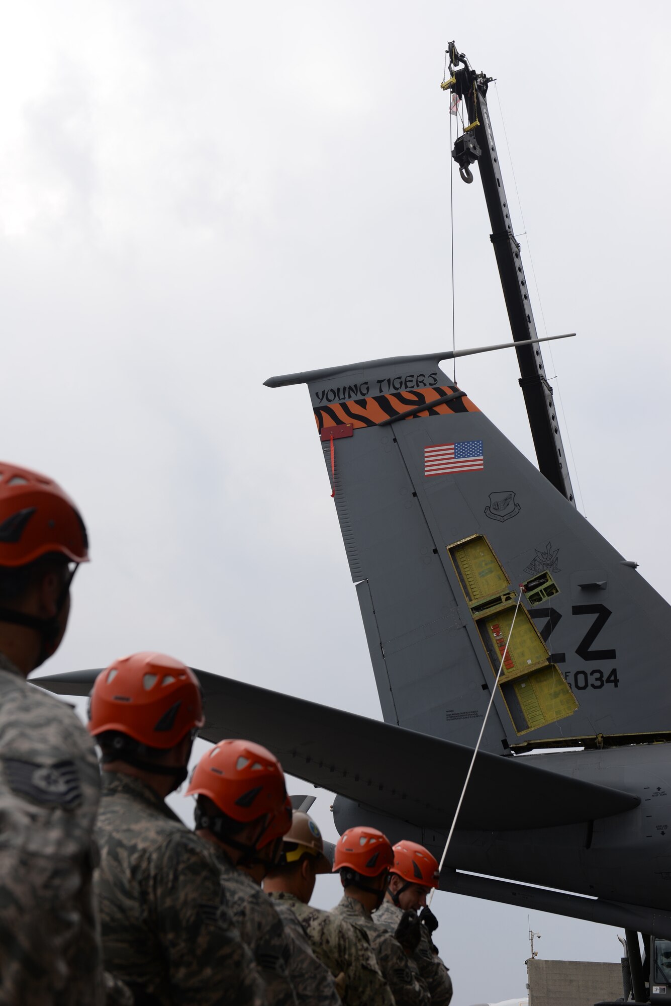 U.S. Air Force Airmen of the 18th Aircraft Maintenance Squadron and a U.S. Navy Seabee construction man of Naval Mobile Construction Battalion 3 pull on a tag line rope to stabilize a fin fold procedure Jan. 14, 2016, at Kadena Air Base, Japan. The top tail section of a KC-135 Stratotanker required removal for a rudder repair project. (U.S. Air Force photo by Senior Airman Peter Reft)
