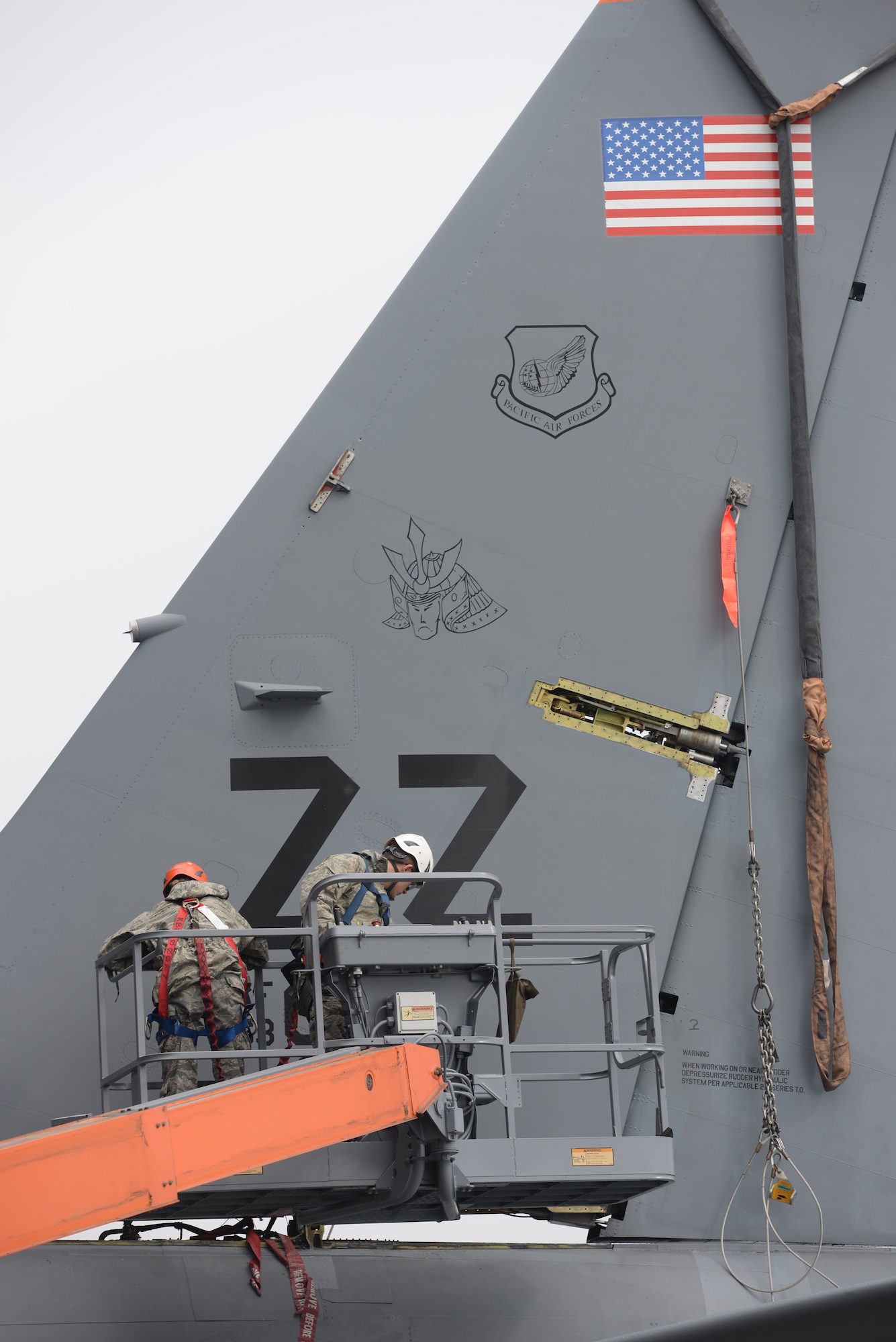 U.S. Air Force Senior Airman Robyne Keller and Staff Sgt. Joseph Tenebruso, 18th Equipment Maintenance Squadron repair and recovery technicians, stabilize the tail section of a KC-135 Stratotanker Jan. 14, 2016, at Kadena Air Base, Japan. Keller and Tenebruso ensured the tail section could be safely lowered for a rudder replacement repair project. (U.S. Air Force photo by Senior Airman Peter Reft)