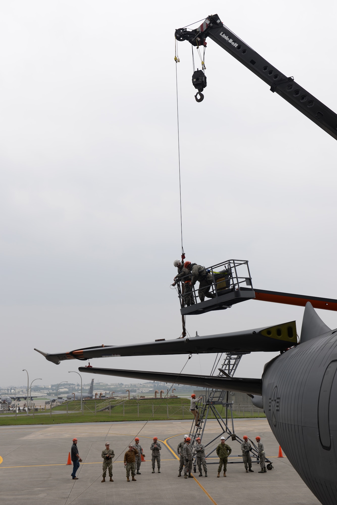 U.S. Air Force Airmen of the 18th Aircraft Maintenance Squadron and a U.S. Navy Seabees of Naval Mobile Construction Battalion 3 use a Link Belt 40-ton crane to fold down the tail fin of a KC-135 Stratotanker Jan. 14, 2016, at Kadena Air Base, Japan. Airmen and Seabees coordinated a joint operation to replace a worn out rudder on the tail section of the aircraft. (U.S. Air Force photo by Senior Airman Peter Reft)