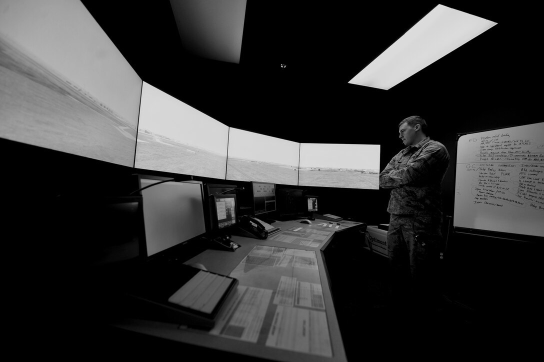 Second Lt. Charles Nichols, 28th Operations Support Squadron airfield operations system officer, studies the conditions of the flightline during a training simulation at Ellsworth Air Force Base, S.D., Jan. 7, 2016. Air traffic controllers use the simulator as a way to keep sharp and be prepared for all scenarios. (U.S. Air Force photo illustration by Airman 1st Class James L. Miller/Released)