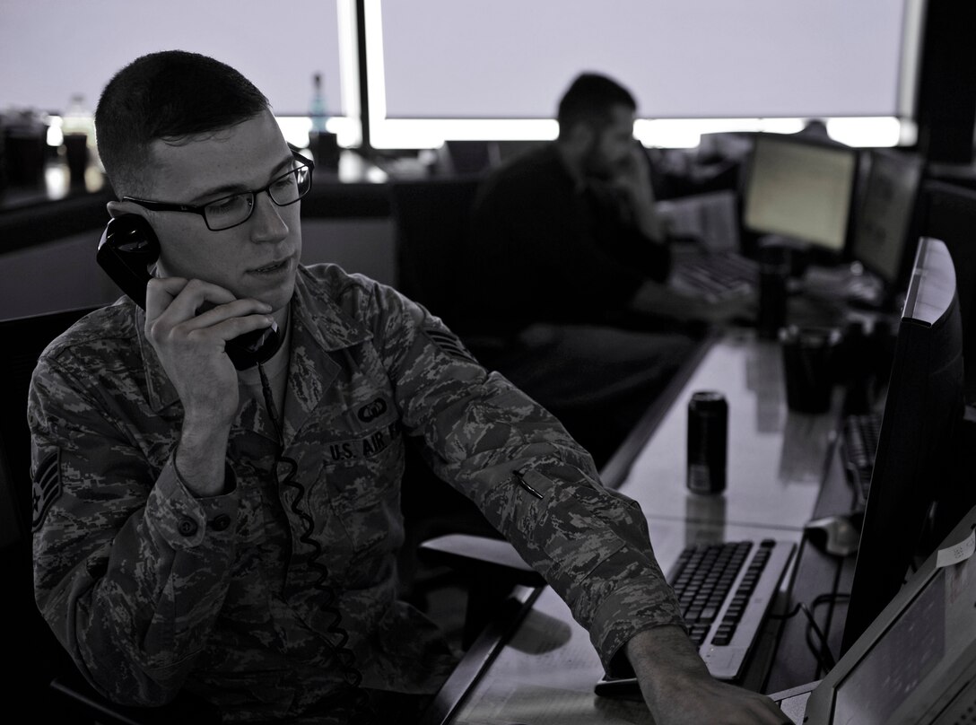 Staff Sgt. Spencer Butler, 28th Operations Support Squadron watch supervisor, communicates with a B-1 bomber pilot preparing to take off at Ellsworth Air Force Base, S.D., Jan. 7, 2016. Air traffic controllers provide vital information to aircraft during take-offs, landings and while in the air. (U.S. Air Force photo illustration by Airman 1st Class James L. Miller/Released)
