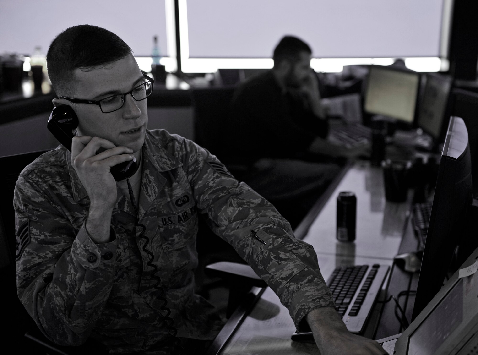 Staff Sgt. Spencer Butler, 28th Operations Support Squadron watch supervisor, communicates with a B-1 bomber pilot preparing to take off at Ellsworth Air Force Base, S.D., Jan. 7, 2016. Air traffic controllers provide vital information to aircraft during take-offs, landings and while in the air. (U.S. Air Force photo illustration by Airman 1st Class James L. Miller/Released)