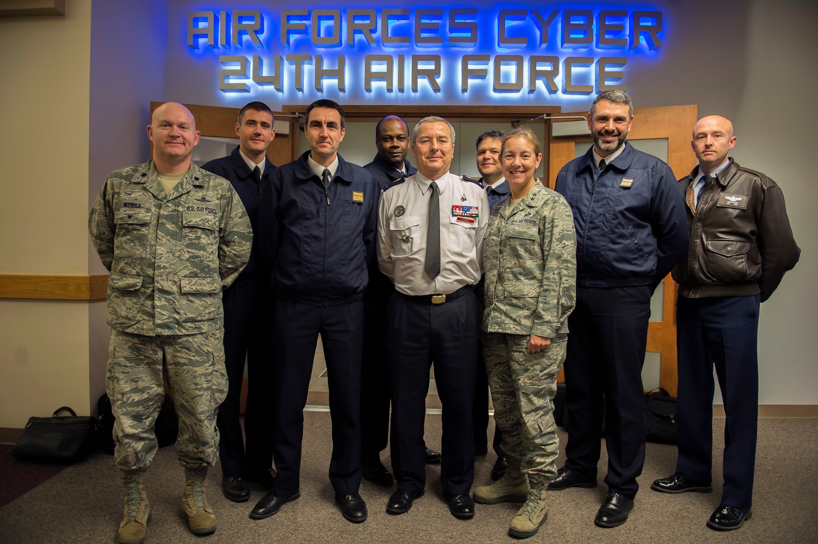 U.S. Air Force Maj. Gen. Shelia Zuehlke (center-right), mobilization assistant to the commander, 24th Air Force and Air Forces Cyber Command (AFCYBER), and French Air Force Brig. Gen. Thierry Combel (center), Deputy Director General of Employment and Training-Air Force Human Resources, stand with other members of a cybersecurity delegation during a visit to Headquarters, 24AF - AFCYBER, Joint Base San Antonio - Lackland, Texas, Jan 13. The delegation visited to discuss how the U.S. and French Air Force’s approach cyber organization, training, and exercise participation as well as to facilitate future partnerships and engagements.. (U.S. Air Force photo by Master Sgt. Luke P. Thelen/Released)