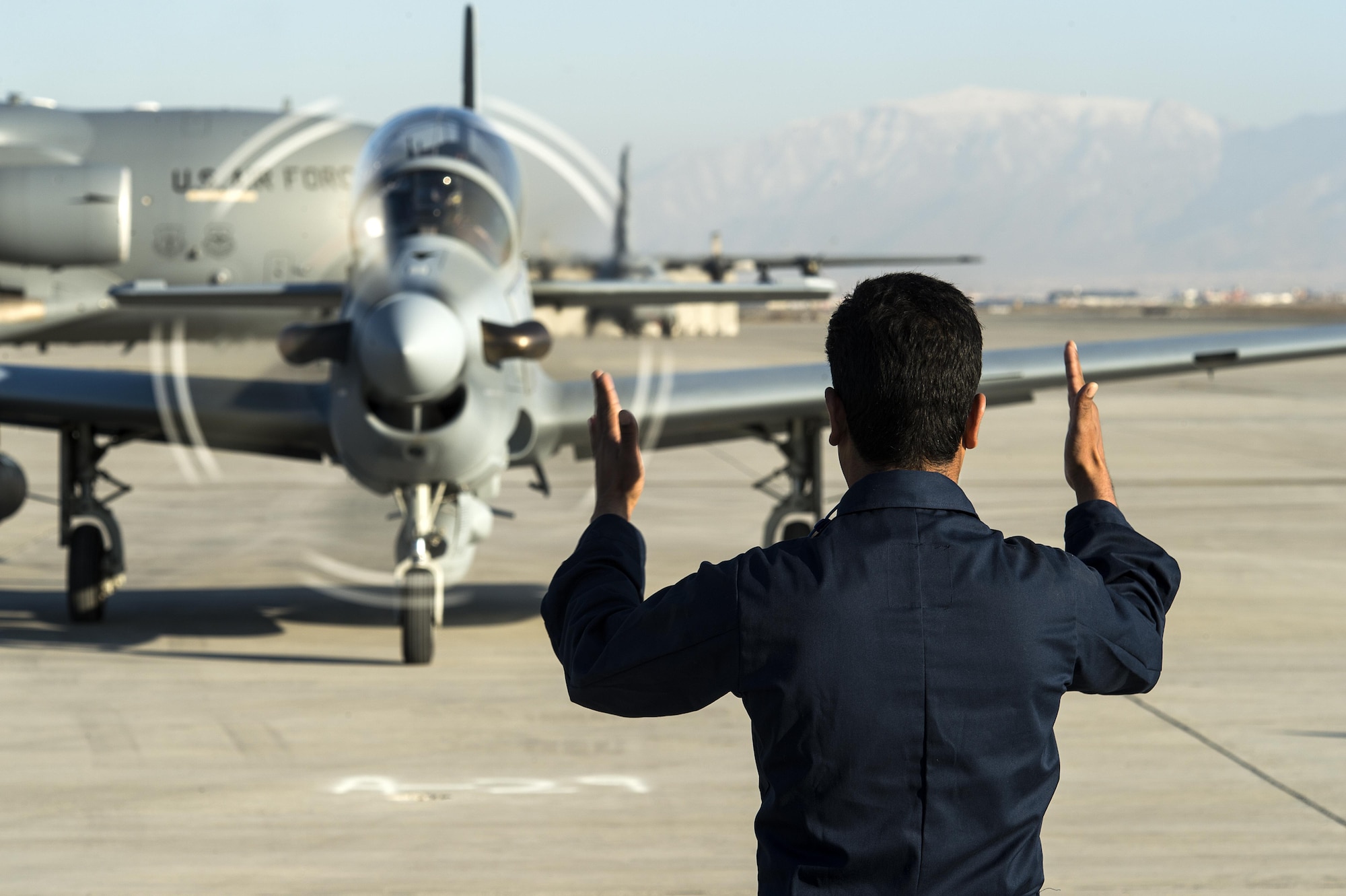 A member of the Afghan air force marshals in an A-29 Super Tucano at Hamid Karzai International Airport, Afghanistan, Jan. 15, 2016. The aircraft will be added to the Afghans' inventory in the spring of 2016. The A-29 Super Tucano is a 'light air support' aircraft capable of conducting close air support, aerial escort, armed overwatch and aerial interdiction. Designed to operate in high temperature and in extremely rugged terrain, the A-29 Super Tucano is highly maneuverable 4th generation weapons system capable of delivering precision guided munitions. It can fly at low speeds and low altitudes, is easy to fly, and provides exceptionally accurate weapons delivery. It is currently in service with 10 different air forces around the world. (U.S. Air Force photo by Tech. Sgt. Nathan Lipscomb)