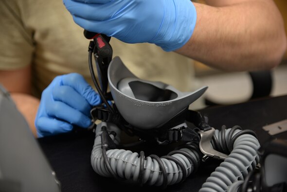 Senior Airman Nathan Fancher, 14th Operation Support Squadron Aircrew Flight Equipment Technician, adjusts the straps on an oxygen mask for a helmet Jan. 12 on Columbus Air Force Base, Mississippi. Equipment that does not perform up to par, or that simply does not fit, poses a threat to anyone who takes to the air. (U.S. Air Force photo/Airman 1st Class John Day)