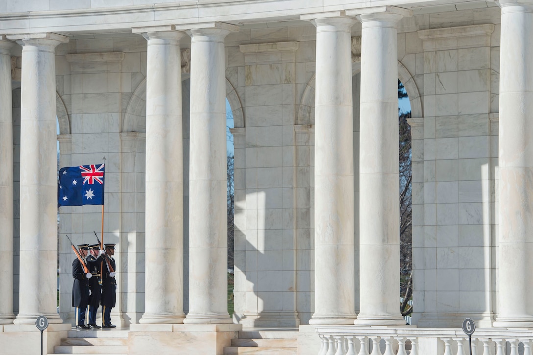 An Army color guard stands  and holds an Australian flag at the Arlington National Cemetery Amphitheater as Defense Secretary Ash Carter and Australian Prime Minister Malcolm Turnbull depart after participating in a wreath-laying ceremony at the Tomb of the Unknown Soldier at  Arlington National Cemetery, Arlington, Va., Jan. 18, 2016. DoD photo by Senior Master Sgt. Adrian Cadiz
